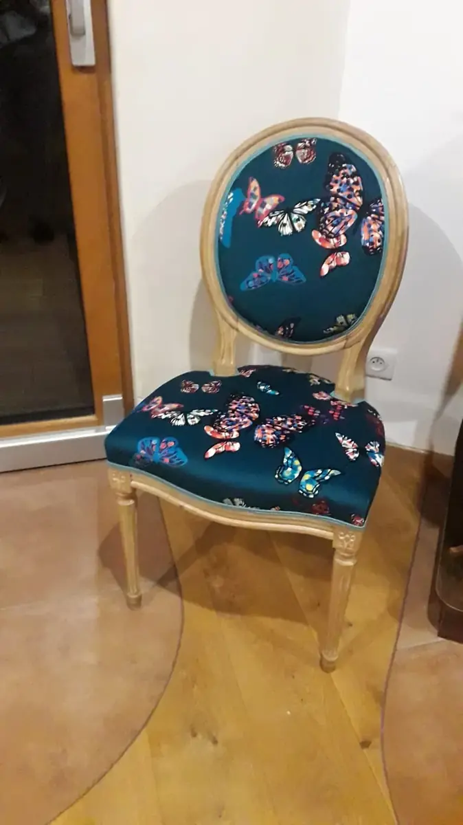 Chaise cabriolet en bois clair, tissu bleu canard à motif de papillons multicolores