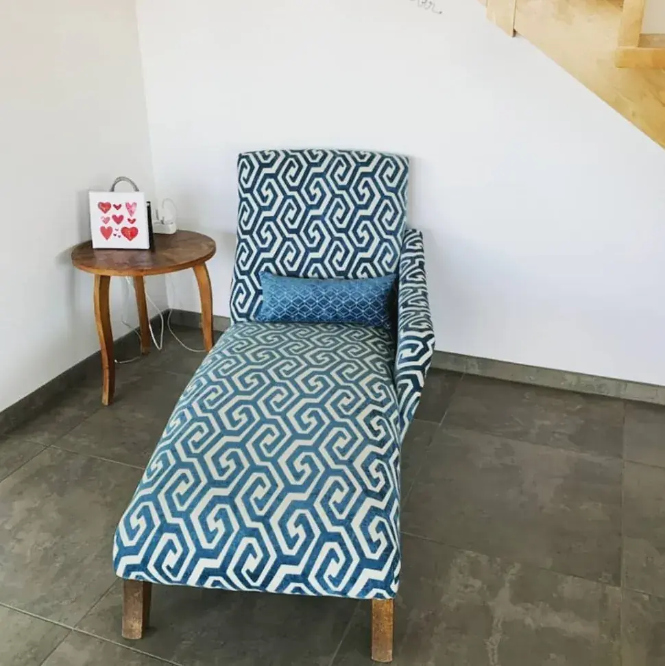 Méridienne en tissu bleu marine et blanc à motif géométrique, près d'un escalier
