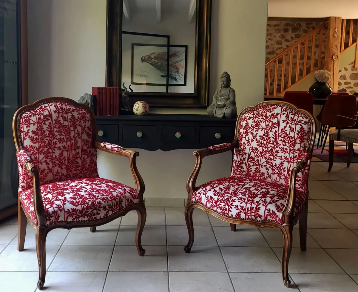 Paire de fauteuils cabriolet en bois sculpté, tissu blanc à motif de branches rouges